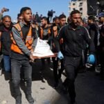صورة أرشيفية تظهر آثار قصف في قطاع غزة، مع دخان يتصاعد من مبانٍ متضررة.