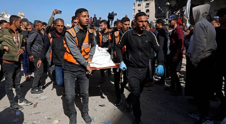 صورة أرشيفية تظهر آثار قصف في قطاع غزة، مع دخان يتصاعد من مبانٍ متضررة.