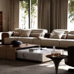 Eureka Ergonomic Arundel Collection modular sofa with warm walnut, tobacco leather, and ivory upholstery, showcasing visible seams.