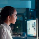 Une femme travaillant sur un ordinateur avec des éléments visuels d'intelligence artificielle, symbolisant l'innovation et l'inclusion féminine dans la technologie au Maroc.