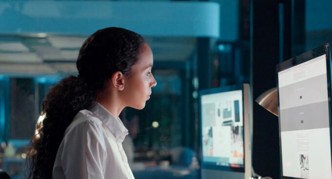 Une femme travaillant sur un ordinateur avec des éléments visuels d'intelligence artificielle, symbolisant l'innovation et l'inclusion féminine dans la technologie au Maroc.