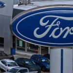 Ford F-Series pickup trucks on a dealership lot, representing U.S. auto sales.