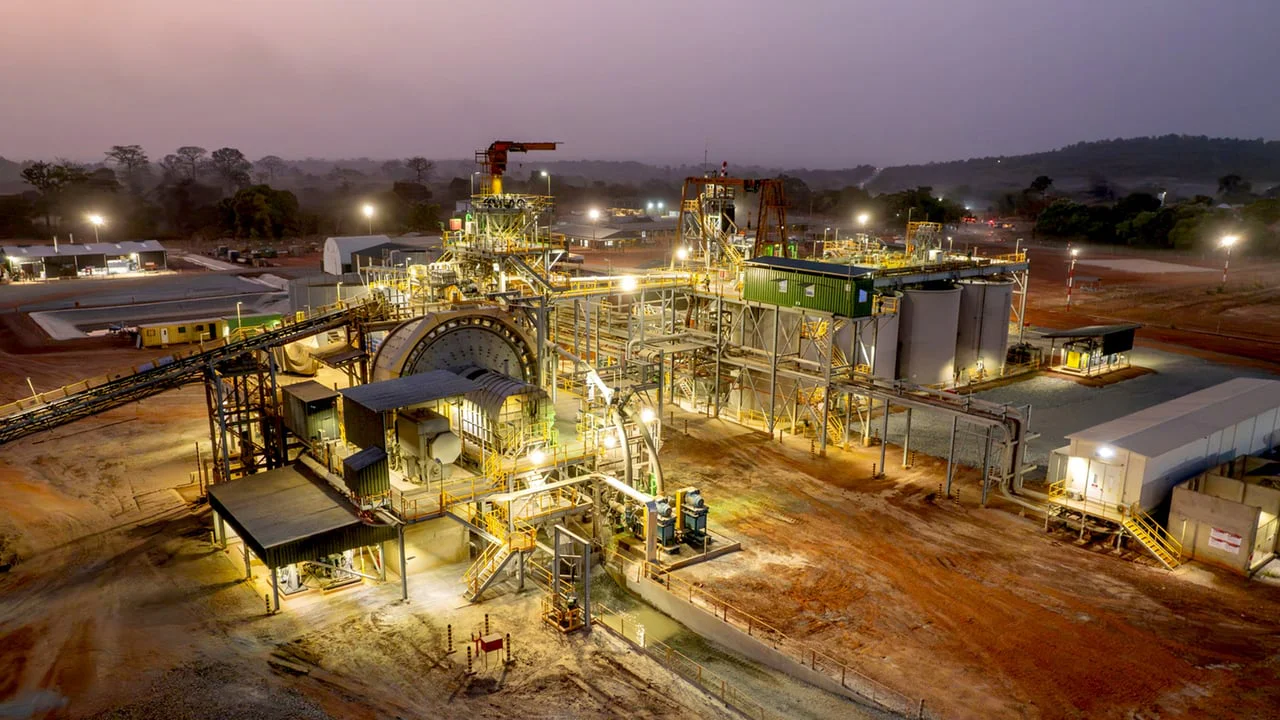 Vue aérienne d'une mine d'or en activité en Afrique de l'Ouest, avec des équipements lourds et des bassins de traitement, symbolisant l'expansion de Fortuna Mining.