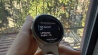 A close-up of a Garmin smartwatch screen displaying battery life, with an overlay indicating the 'OK Garmin' voice assistant feature.