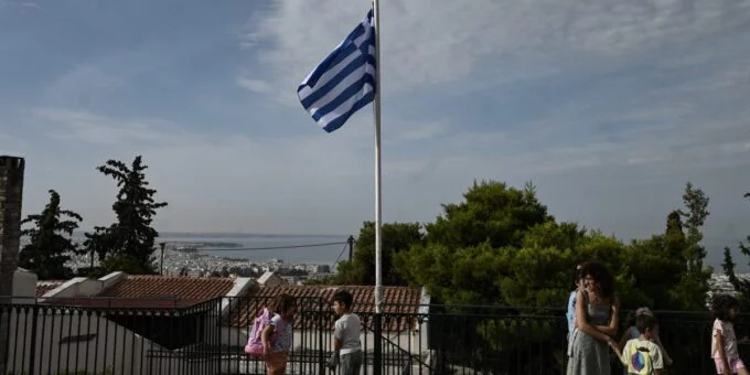 The Silent Exodus: Greece's Island Schools Battle Demographic Decline 10 Chryssa Ntalaka, the last teacher on Kalamos, sitting with her two remaining students in a classroom with many empty desks.