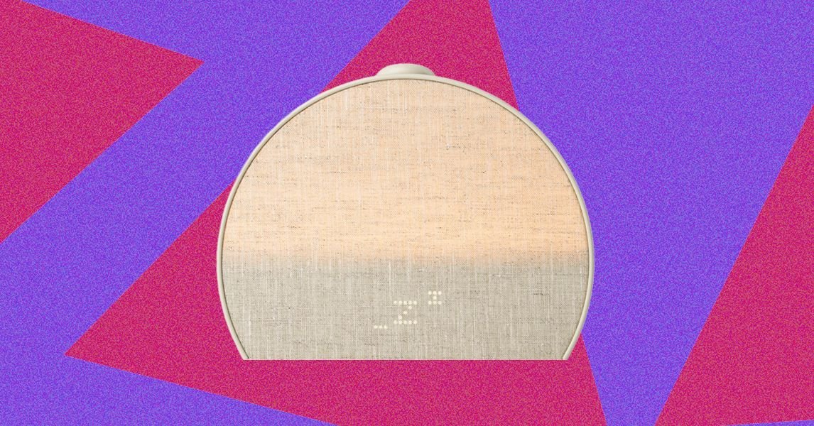 A Hatch Sleep Clock device on a nightstand, emitting a soft light.