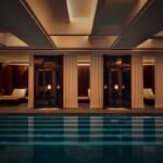 Parisian Oasis Unveiled: Liaigre Transforms Hôtel Costes Spa into a Sanctuary of Luxury 6 Luxurious swimming pool with lagoon mosaic and curtained lounge nooks at the Hôtel Costes spa, designed by Liaigre.