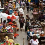 Un marché animé en Afrique subsaharienne avec des étals de fruits et légumes, symbolisant l'impact de l'inflation sur les produits de base et l'insécurité alimentaire.