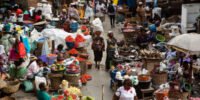 Un marché animé en Afrique subsaharienne avec des étals de fruits et légumes, symbolisant l'impact de l'inflation sur les produits de base et l'insécurité alimentaire.
