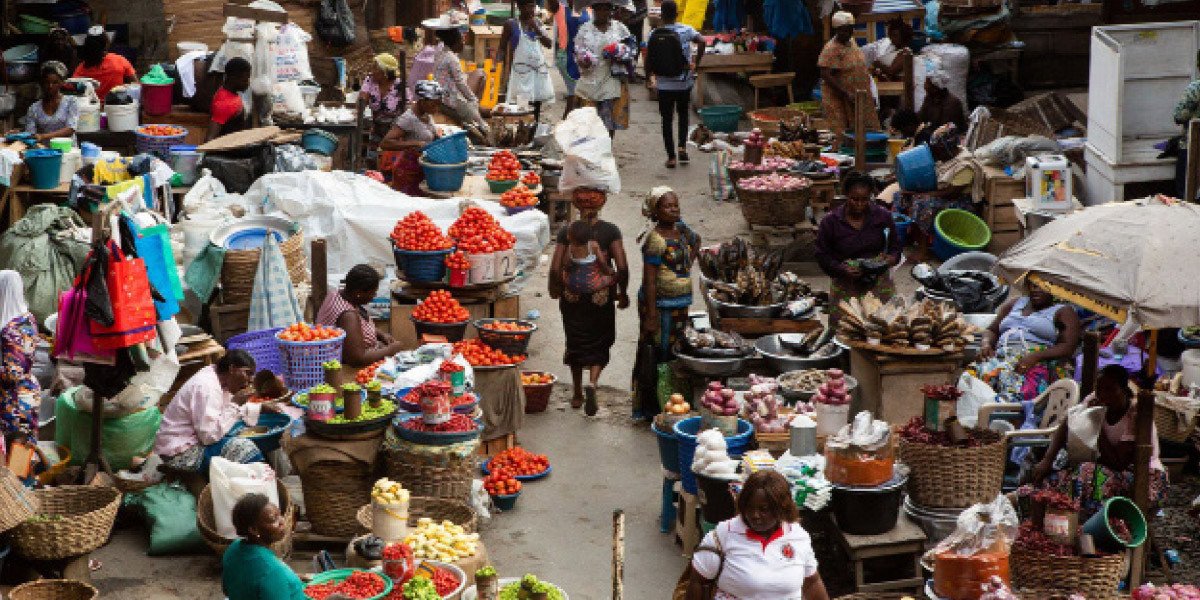 Un marché animé en Afrique subsaharienne avec des étals de fruits et légumes, symbolisant l'impact de l'inflation sur les produits de base et l'insécurité alimentaire.