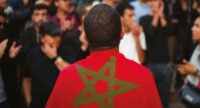 Un groupe de jeunes marocains engagés, discutant et souriant, symbolisant la participation active à la vie publique.