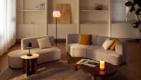 A cozy living room illuminated with warm, layered smart lighting for autumn ambiance.