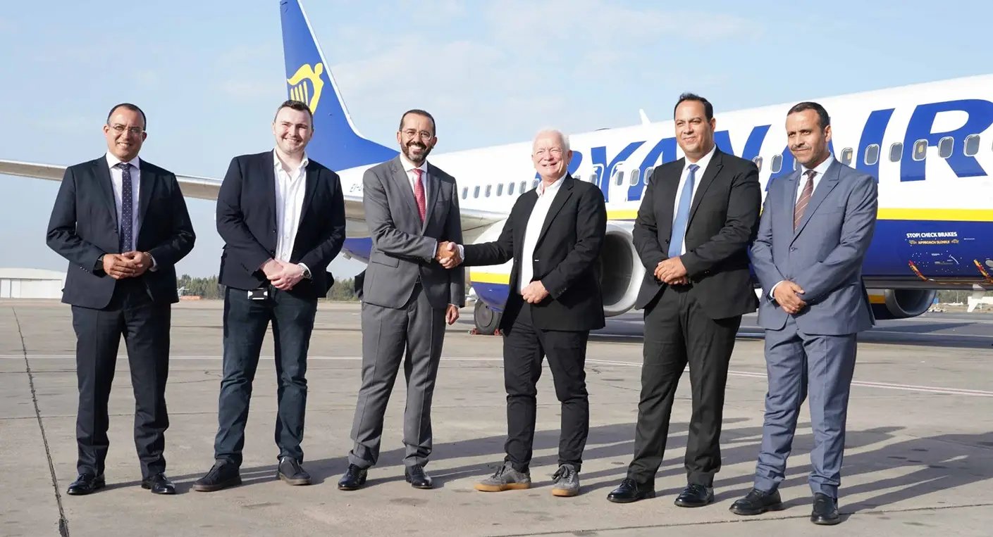 Eddie Wilson, PDG de Ryanair, serrant la main d'un représentant de l'ONMT, avec un avion Ryanair en arrière-plan symbolisant l'expansion au Maroc.