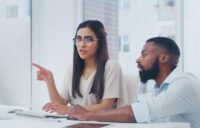 A leader looking into a mirror, seeing reflections of team members and systemic issues.