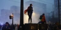 Manifestants défilant dans la rue sous la surveillance des forces de l'ordre lors des manifestations du 24 octobre.