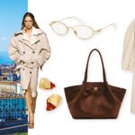 Une femme élégante, le visage partiellement masqué par des lunettes ovales, porte un trench-coat beige fluide et une chemise blanche oversize, avec un sac à bandoulière et des chaussures à plateforme imprimé python, illustrant un style urbain chic.