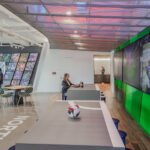 Interior view of the MLS headquarters reception area with club jerseys and the MLS Cup display.