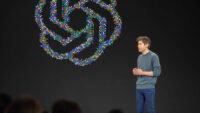 Sam Altman, CEO of OpenAI, speaking at a developer conference, illustrating the company's financial news.