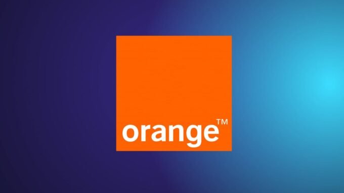 Un smartphone affichant le logo Orange, symbolisant la panne du réseau mobile et son rétablissement progressif, avec un fond flou de ville.