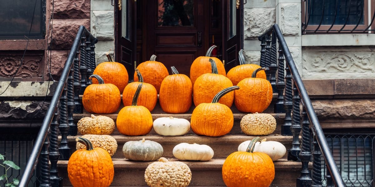 The Great Gourd Getaway: Americans Splurge Up to $2,000 for Professional Pumpkin Porch Styling, Fueling a Six-Figure Franchise Boom 3 A beautifully arranged autumn pumpkin display on a luxurious front porch, featuring various sizes and types of gourds, with a welcoming doormat.