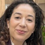La militante écologiste Rania Kissi à Saint-Denis, souriante et engagée, lors d'un événement politique.