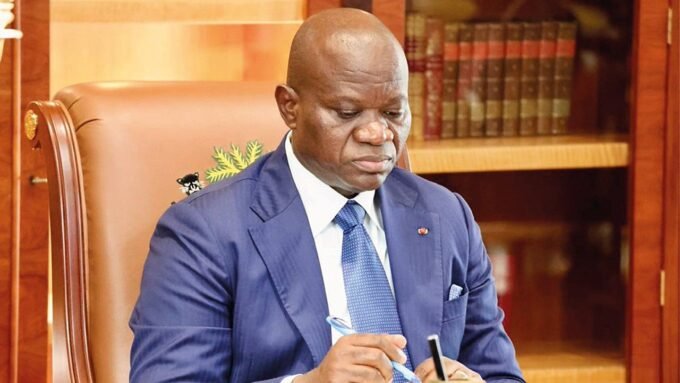 Le président gabonais Brice Clotaire Oligui Nguema en costume, souriant, lors d'une cérémonie officielle.