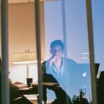 A person looking stressed while reviewing financial documents, symbolizing the struggle of mixed personal and business finances.