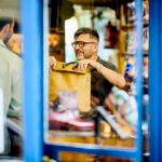 A small business owner smiling and interacting positively with a customer, symbolizing strong customer relationships and loyalty.