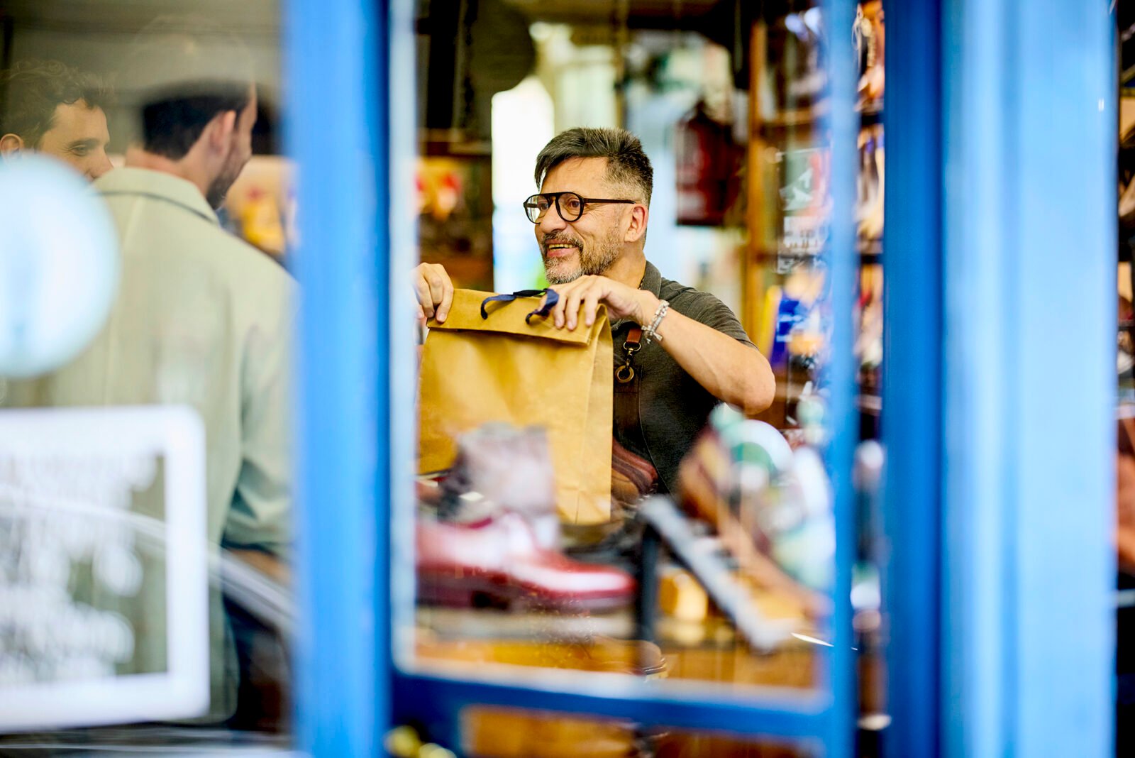 A small business owner smiling and interacting positively with a customer, symbolizing strong customer relationships and loyalty.