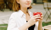 A steaming cup of black tea, symbolizing warmth and heart health, with a blurred background of a healthy lifestyle scene.