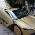 Tesla Cybercab displayed in downtown Austin, Texas, a bronze two-seater driverless vehicle.