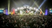 Scène de concert en plein air sur la Place Rachidi à Casablanca, avec des artistes en performance et une foule enthousiaste célébrant la Fête de l'Unité.
