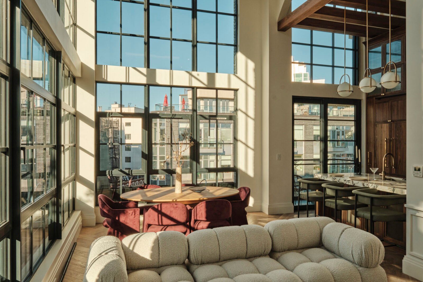 A modern duplex living space in Williamsburg, Brooklyn, featuring high ceilings, large steel-framed windows, and elegant interior finishes.